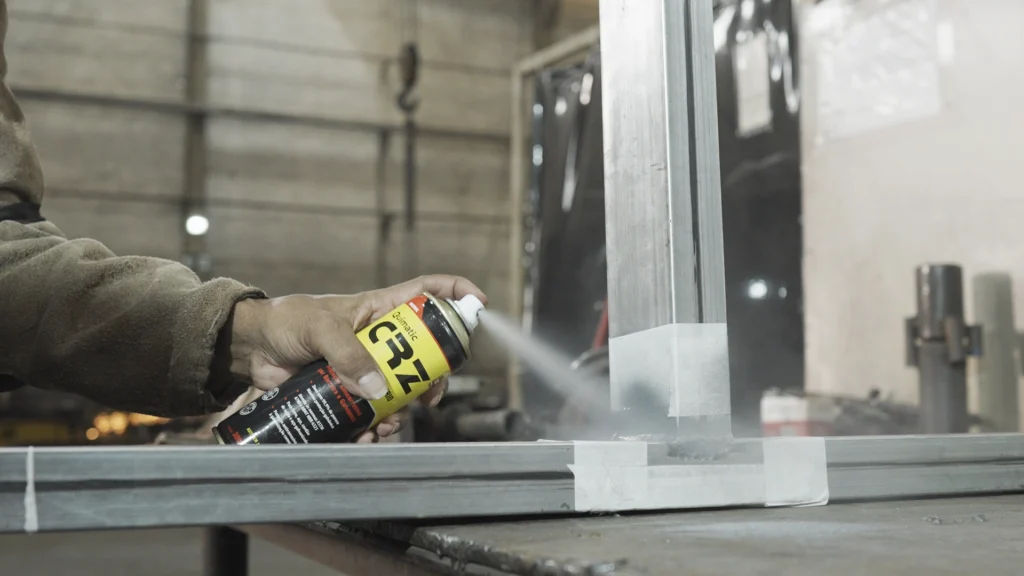 Aplicação do CRZ spray em estrutura metálica com área protegida por fita.