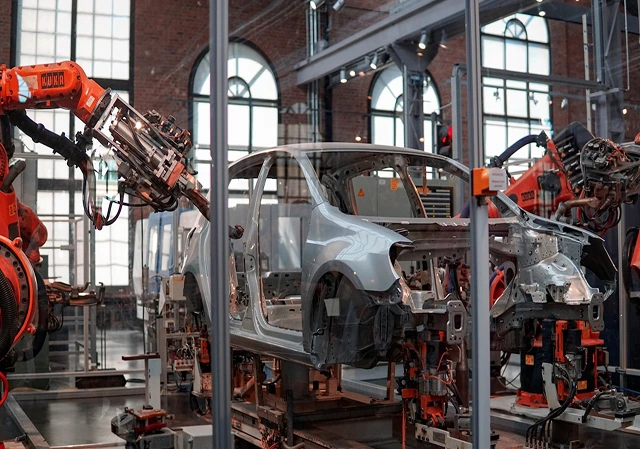 Linha de produção no setor automotivo com carroceria e robôs industriais.