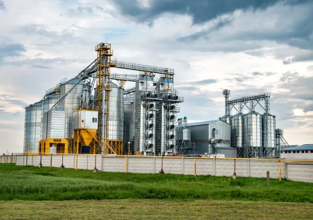 Usina sucroalcooleira com silos e estruturas metálicas industriais.