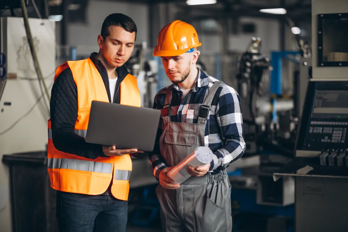 Dois homens checando a manutenção industrial em uma indústria