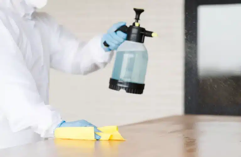 aplicação de produto de limpeza em superfície com borrifador representando tipos de desengraxante